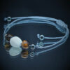 Bracelet en pierres naturelles avec Œil de Tigre, Pierre de Lune et Hématite, monté sur fil macramé ajustable. Allie élégance et protection pour un équilibre énergétique quotidien.