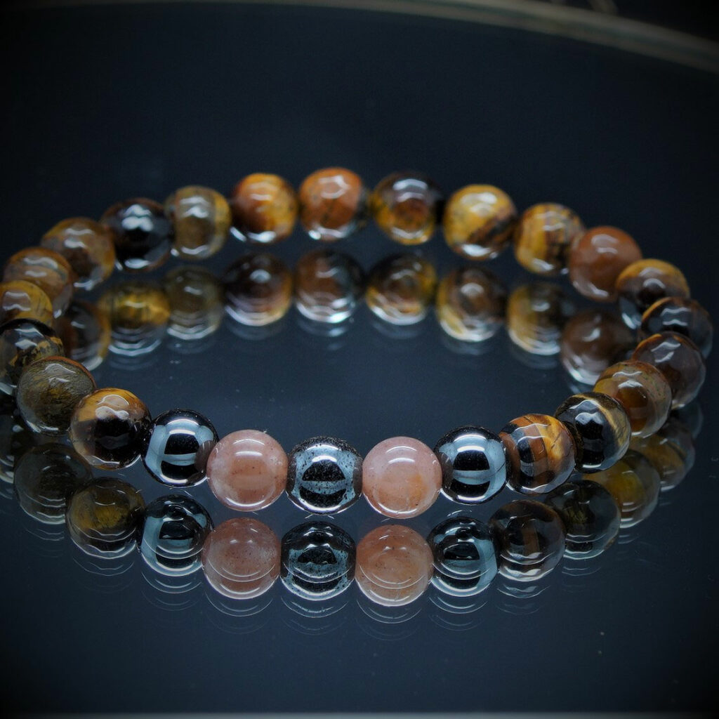 Bracelet en pierres naturelles avec Oeil de Tigre, Pierre de Lune et Hématite monté sur fil élastique. Élégant et protecteur, il favorise l'amour et l'apaisement.