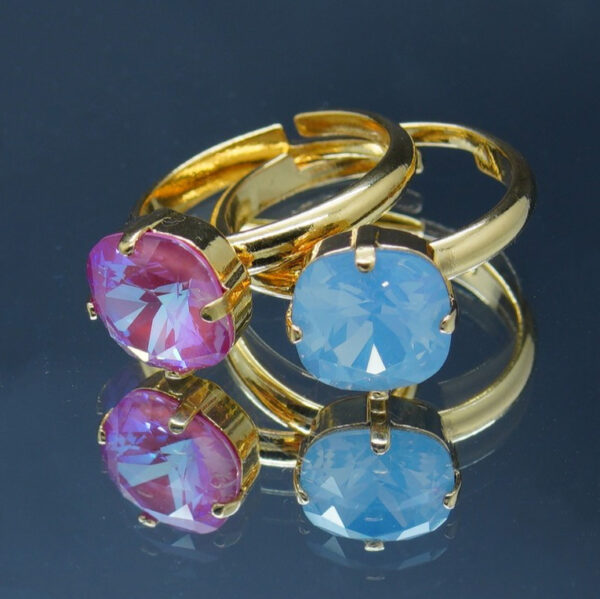 2 Bagues dorées ajustables avec crystaux rose et bleu de haute qualité 10 x 10 mm. Élégantes et intemporelle, elles offrent un éclat raffiné et un confort sur mesure.