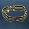 Bracelet tissé à la main sur 4 rangs avec perles Miyuki doréeset gun métal, et finitions en acier inoxydable doré. Un bijou élégant et raffiné, au design fin et lumineux.