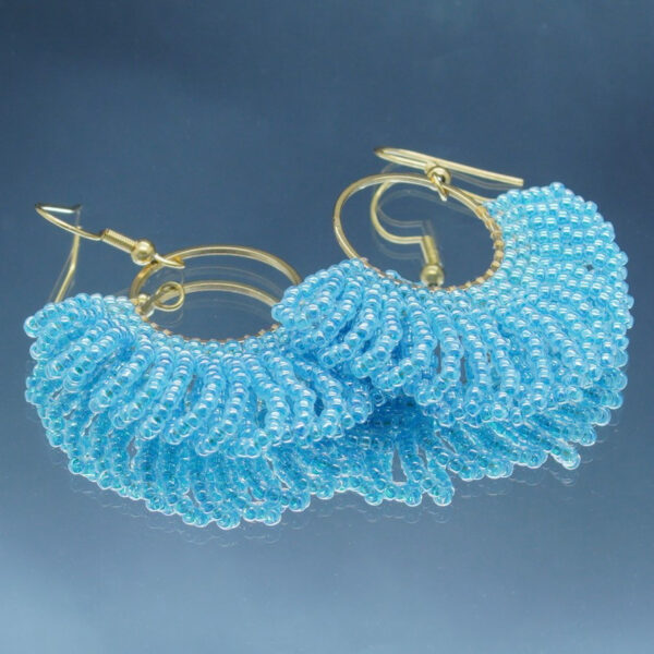 Boucles d'oreilles dorées en perles bleu pâle tressées à la main, en forme d'éventail. Un bijou raffiné et lumineux au design élégant et sophistiqué.