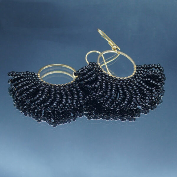 Boucles d'oreilles dorées en perles noires tressées à la main, en forme d'éventail. Un bijou raffiné et lumineux au design élégant et sophistiqué.