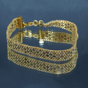 Bracelet tissé en perles Miyuki bronze et doré, formant un motif géométrique élégant. Encadré de chaînettes dorées et doté d’un fermoir ajustable, il allie finesse et sophistication pour un style intemporel et raffiné.