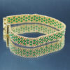 Bracelet tissé en perles Miyuki vert et doré, formant un motif géométrique élégant. Encadré de chaînettes dorées et doté d’un fermoir ajustable, il allie finesse et sophistication pour un style intemporel et raffiné.