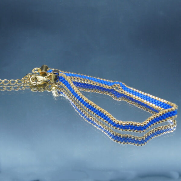 Bracelet tissé à la main sur 4 rangs avec perles Miyuki dorées et bleu cobalt, et finitions en acier inoxydable doré. Un bijou élégant et raffiné, au design fin et lumineux.