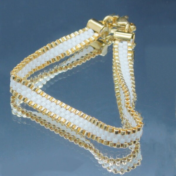 Bracelet tissé à la main sur 4 rangs avec perles Miyuki dorées et blanches, et finitions en acier inoxydable doré. Un bijou élégant et raffiné, au design fin et lumineux.