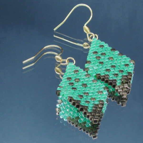 Paire de boucles d’oreilles en forme de losange, tissées à la main avec des perles Cube Miyuki aux nuances de bronze et de vert, créant un effet scintillant et profond. Les reflets subtils rappellent un ciel étoilé. Montées sur des crochets dorés en acier inoxydable avec embouts en silicone, ces boucles sont légères et confortables à porter.