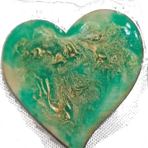 Broche artisanale en forme de cœur et en bois gravé, décorée de vert avec des reflets d'or.