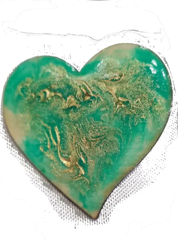 Broche artisanale en forme de cœur et en bois gravé, décorée de vert avec des reflets d'or.