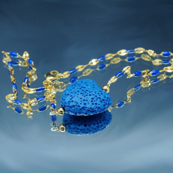 Chaîne de cheville dorée avec perles blanches et cœur en pierre de lave poreuse, idéale pour diffuser des huiles essentielles anti-moustiques avec élégance.